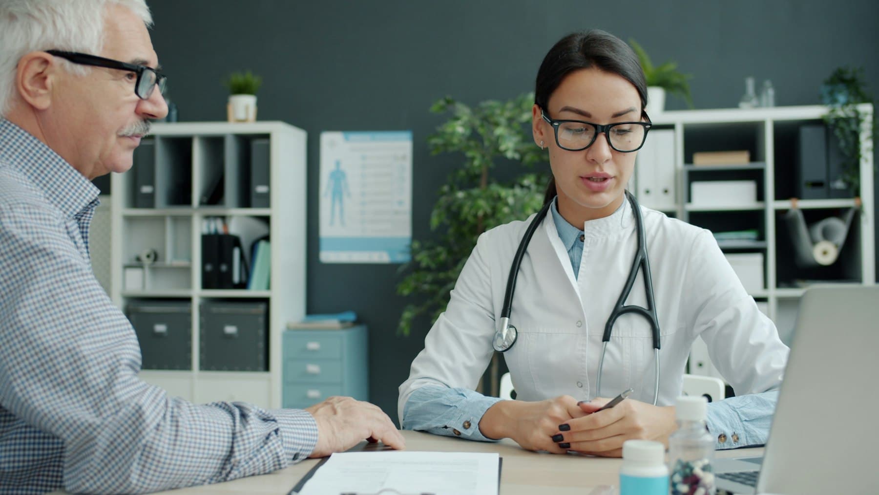 Une médecin en consultation avec un patient âgé.