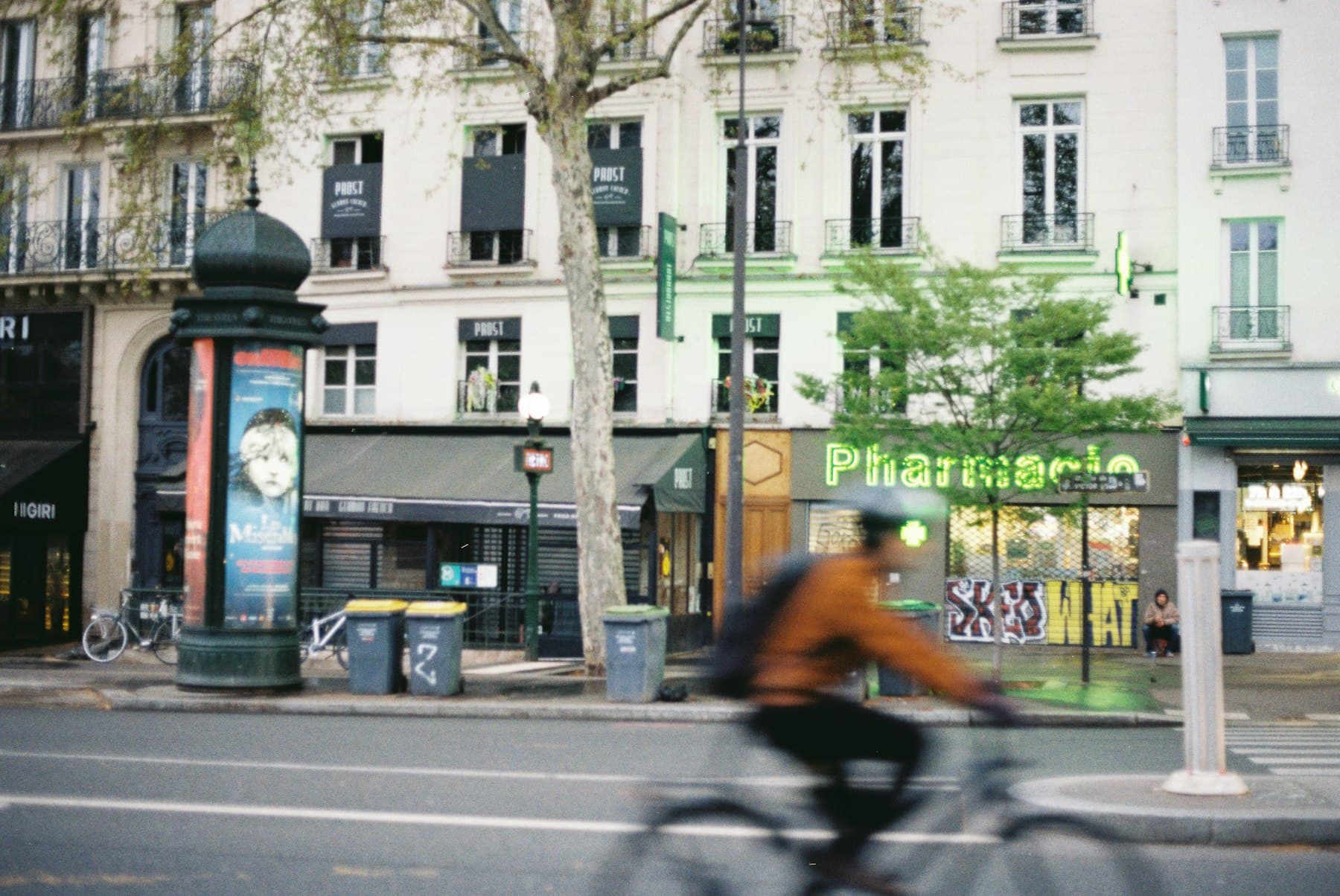 Une rue de ville avec une pharmacie.